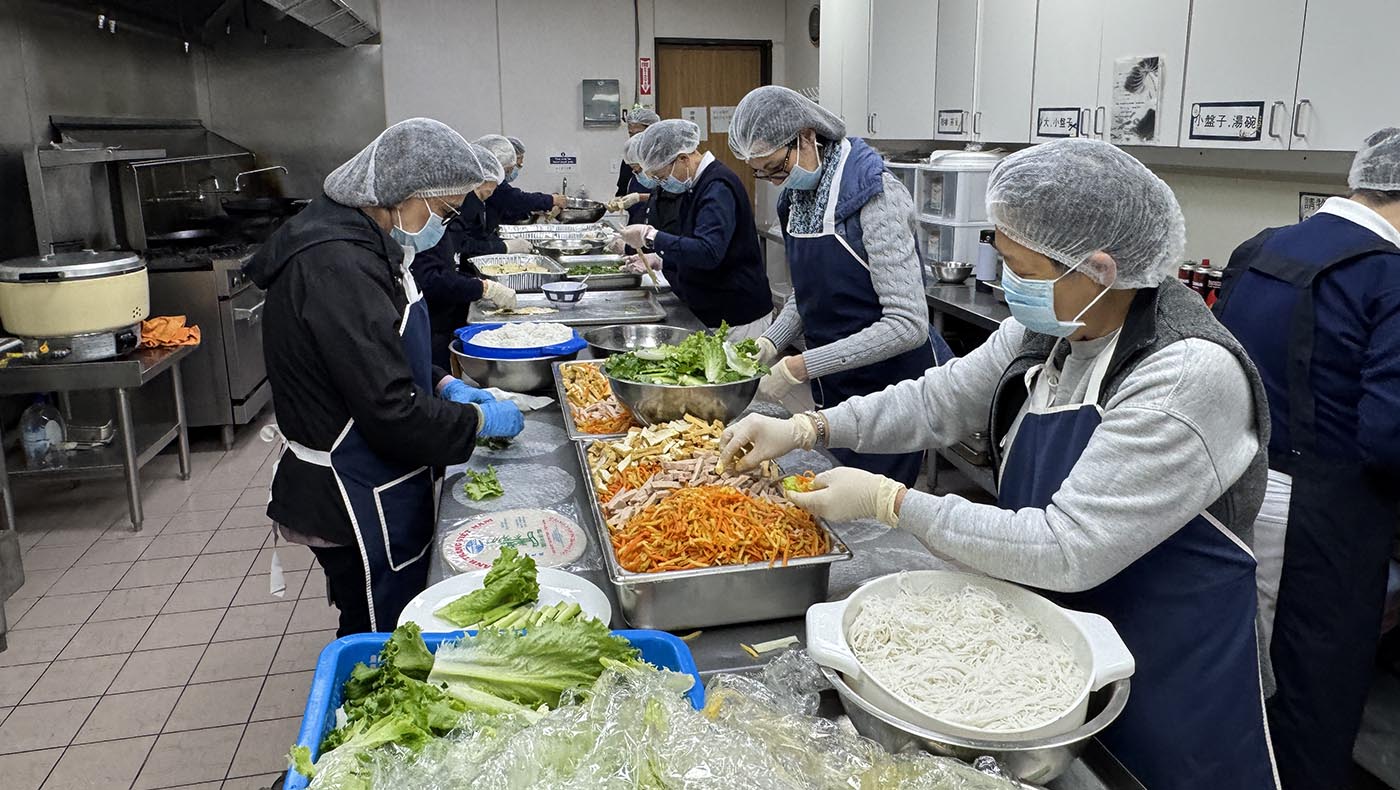 香積團隊在廚房忙碌地準備蔬食餐點的身影。攝影／許維真