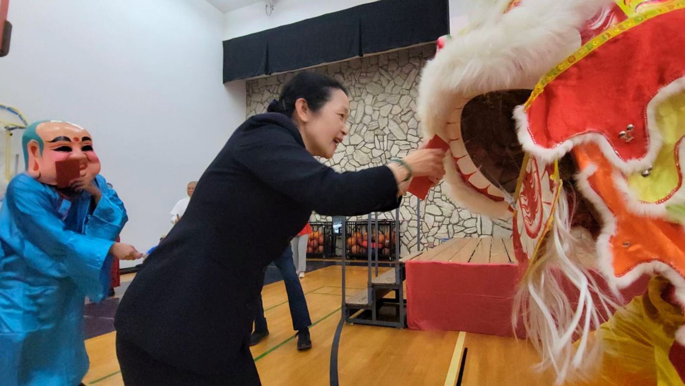 蒙洛維亞幼兒園帶來了舞獅表演，慈濟美國教育基金會執行長李瓊薰（左）按民俗傳統給獅子紅包。攝影／蔡怡暄
