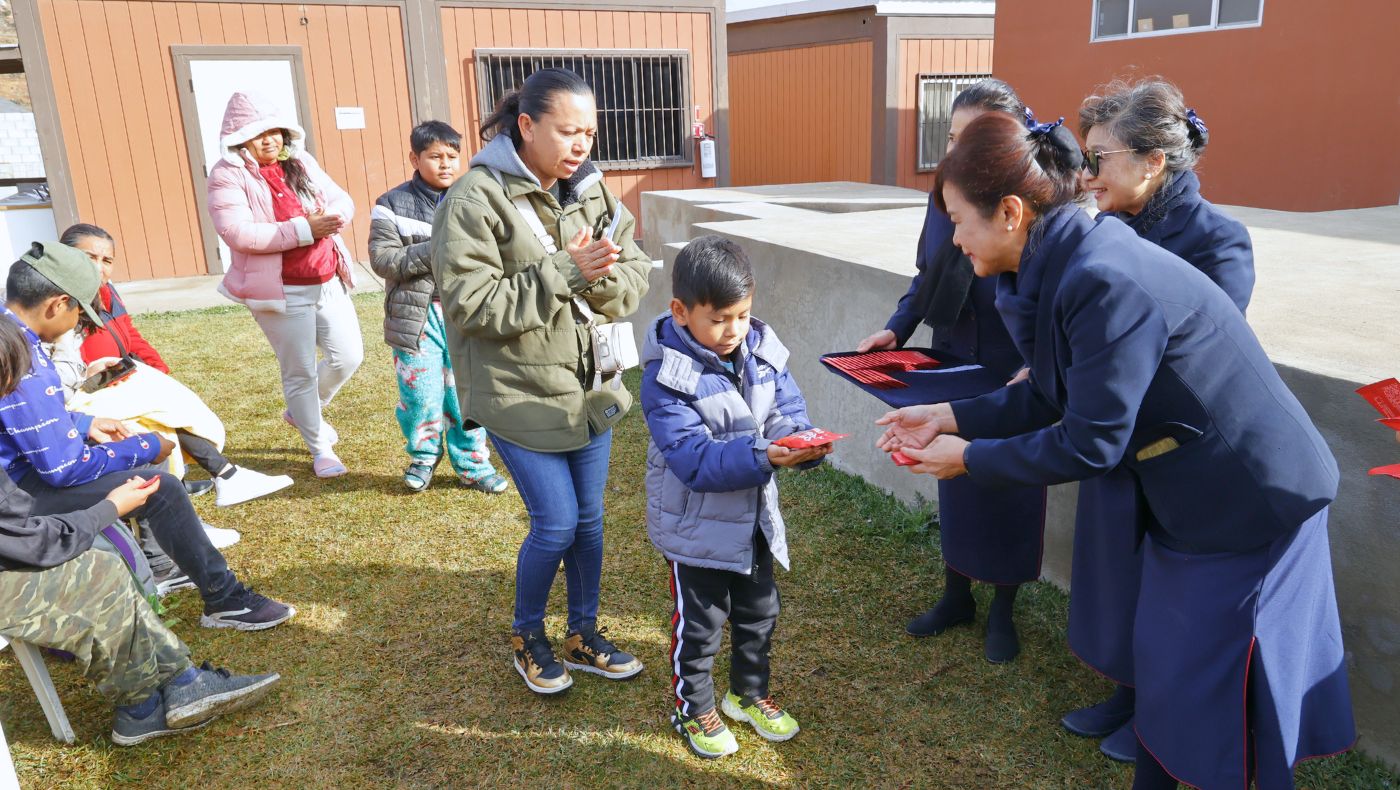 慈濟志工代表證嚴法師發送「福慧紅包」，小孩子有一包喜氣洋洋的米果點心。攝影／駱淑麗