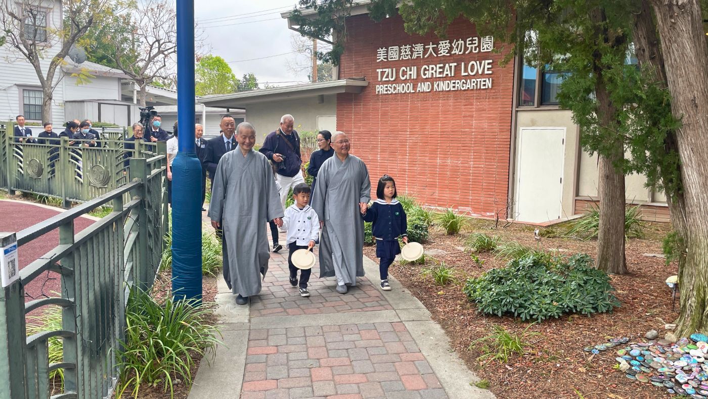關懷團參訪慈濟蒙洛維亞大愛幼兒園，了解學童上課的情況。德悅師父（前排左）、德瑋師父（前排右）牽著歡迎參訪團的孩子。攝影／錢美臻