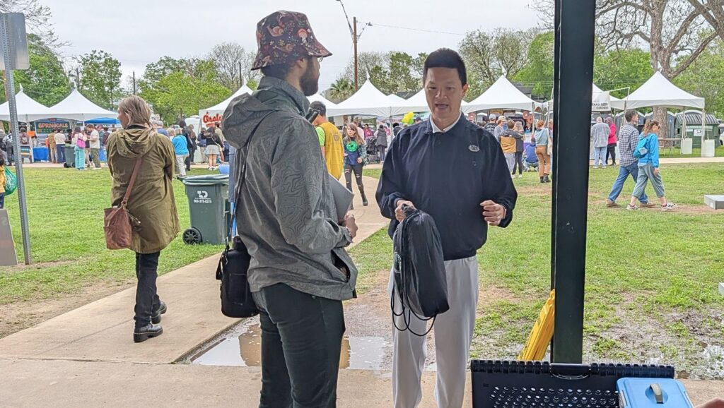 志工劉衍平向會眾透過環保毛毯及福慧床，介紹慈濟及慈悲科技產品。攝影／黃芳文