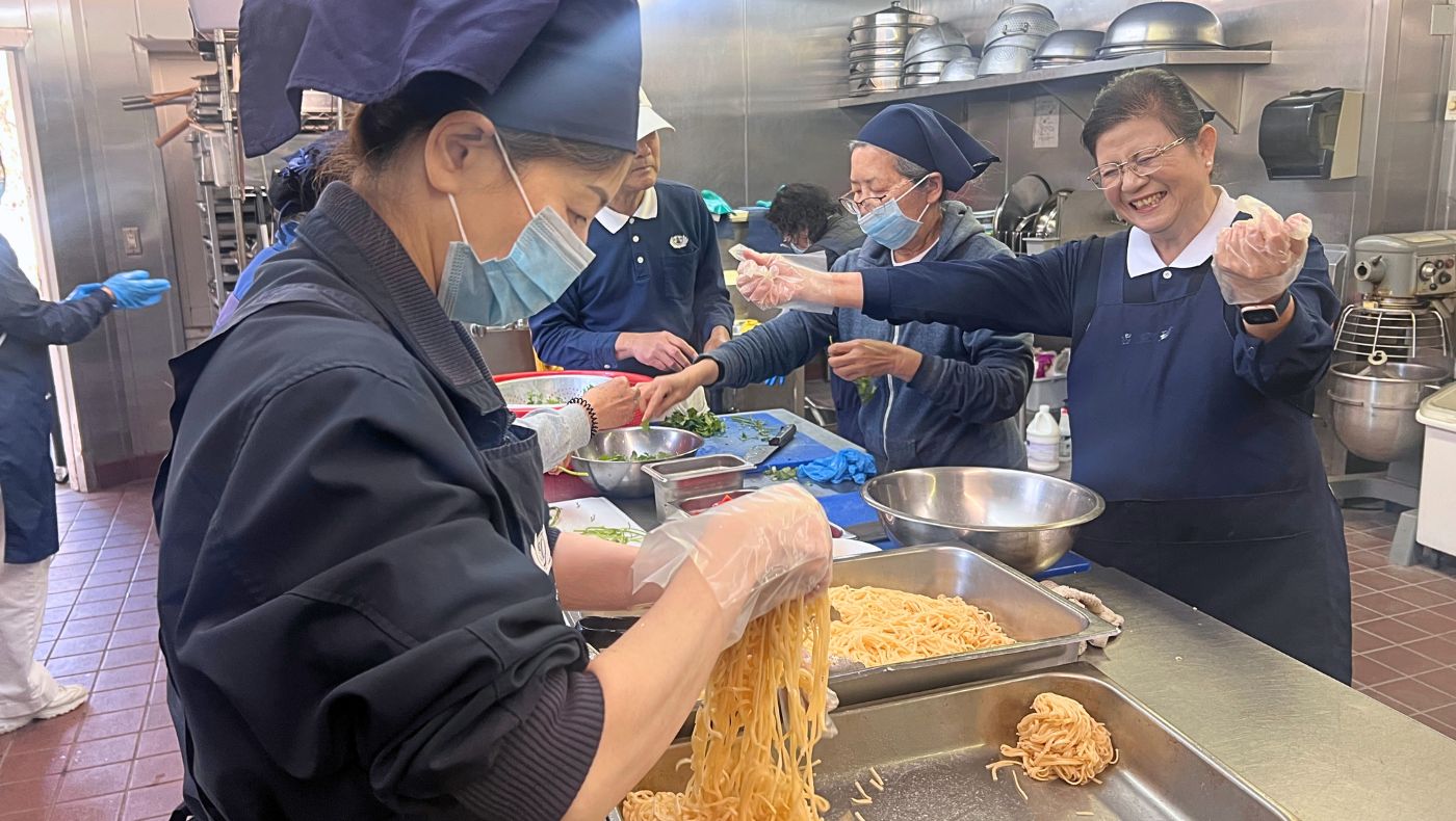 慈濟香積志工歡細地在廚房煮素菜壽麵。攝影／李心怡