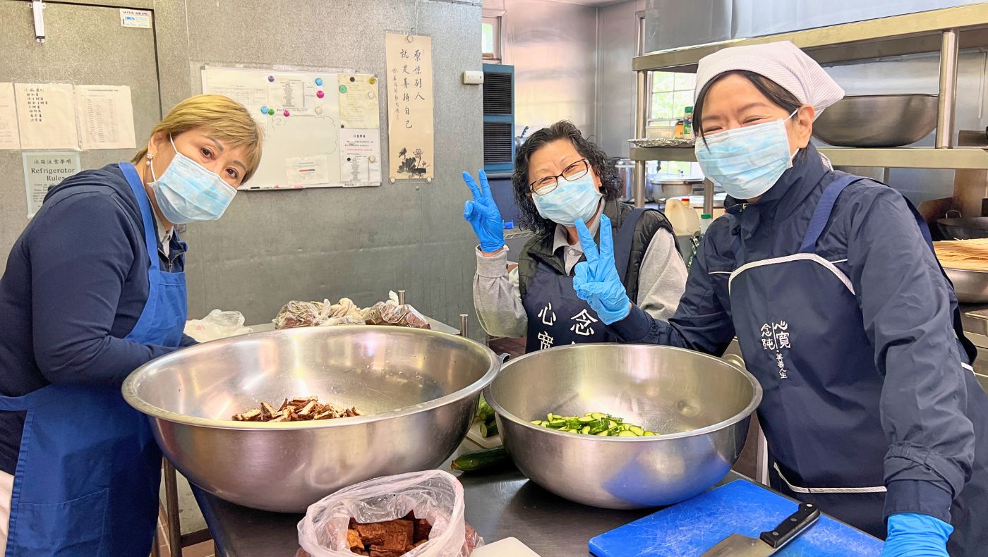 慈濟香積志工歡細地在廚房煮素菜壽麵。攝影／李心怡