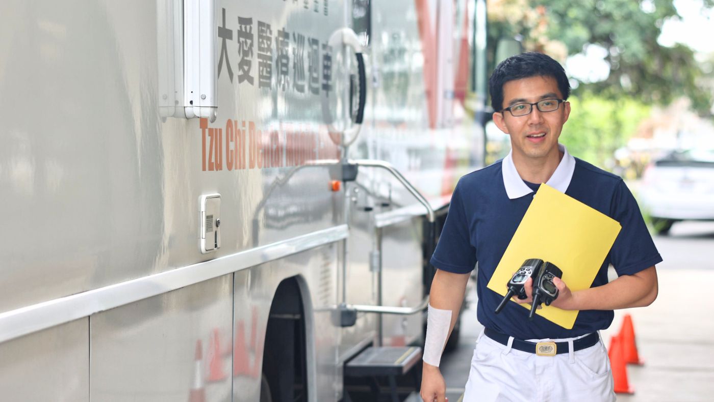 With two walkie-talkies on hand, Andrew Liu, who coordinates the clinic, is always ready to help. Photo/Kitty Lu