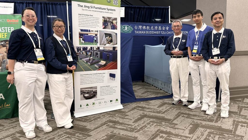 Tzu Chi representatives stand in front of the Tzu Chi booth for a photo. Photo/Tzu Chi USA National Headquarters