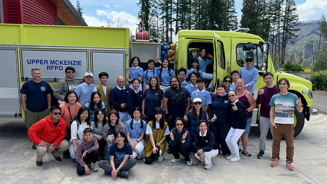 During their visit to the Upper McKenzie Rural Fire Protection District, the Tzu Chi group poses for a photo with local firefighting heroes in front of a fire truck. Photo/Minru Chao