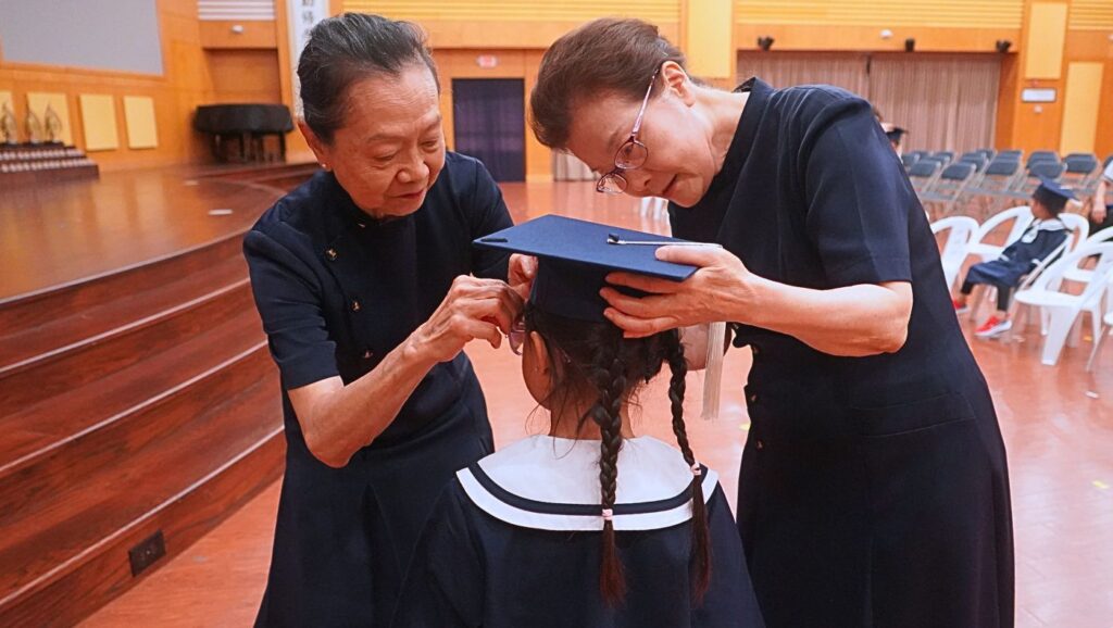 83歲的慈濟志工楊美枝(左)和81歲的慈濟志工林衍秀(右),替小小畢業生們戴上畢業方帽,祝福小朋友們懷著一顆感恩的心,邁向人生新的旅程。攝影/葉晉宏