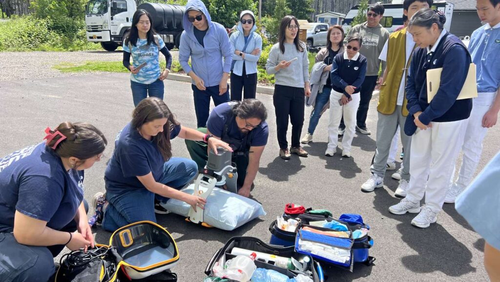 Los miembros del Grupo Juvenil Tzu Chi y sus padres escuchan atentamente mientras los bomberos explican el equipo del camión de bomberos. Foto/Minru Chao