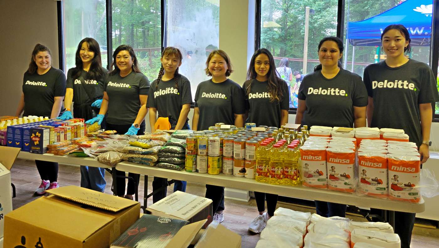 Deloitte volunteers smile joyfully after sorting and neatly arranging supplies for distribution. Photo/Wendy Tsai
