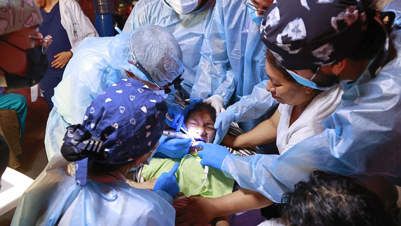 The dental team and Ana Karen’s mother help keep her calm while Dr. Yi Pang Lee cleans her teeth. Photo/Shuli Lo