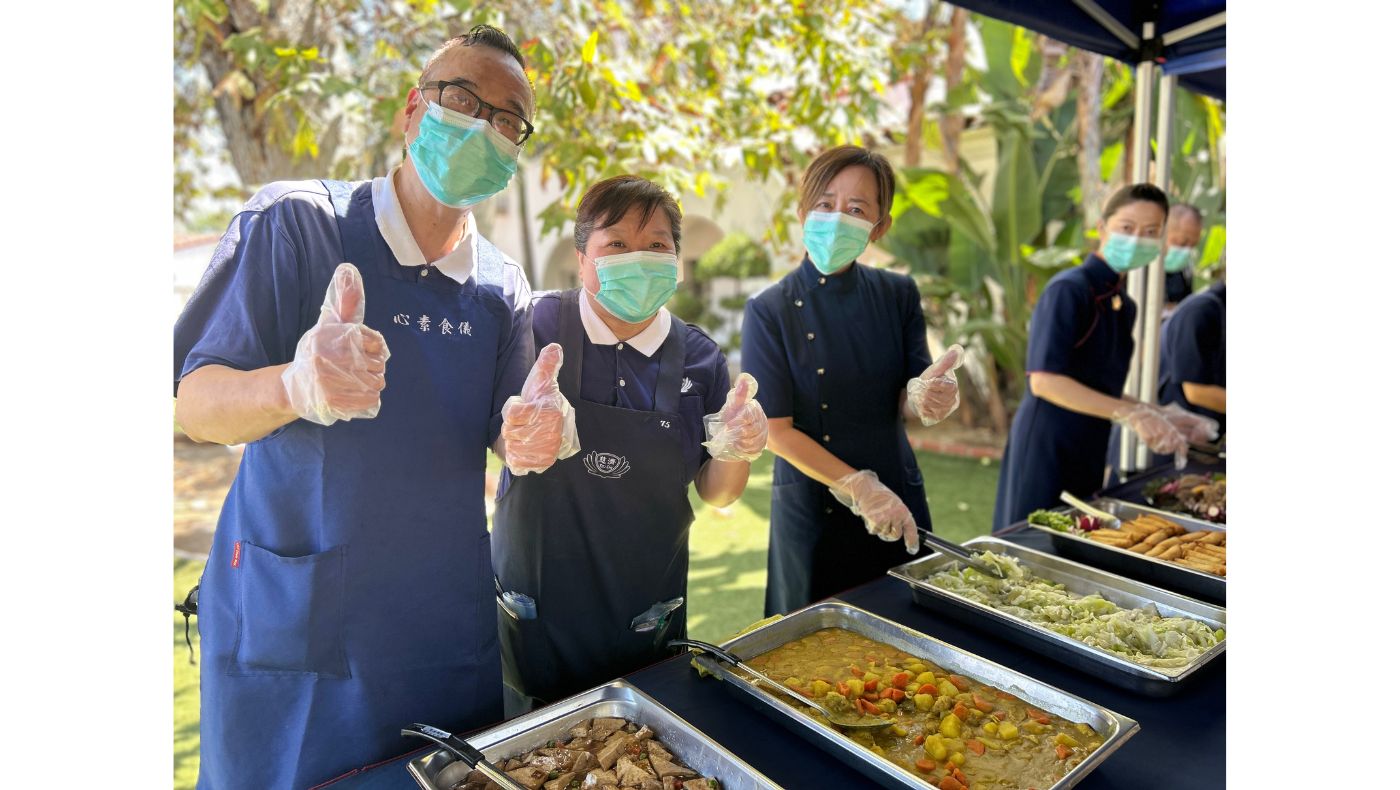 志工滿心歡喜分發素食料理，傳遞吉祥月的喜悅與祝福。攝影／蔡松谷