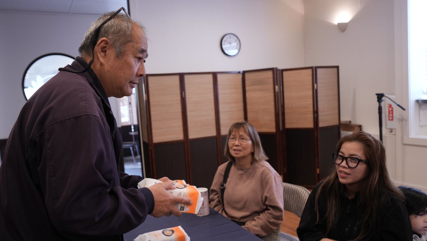 El voluntario Luke Leung presenta la comida de Tzu Chi a los sobrevivientes del desastre. Foto/Renee Liu