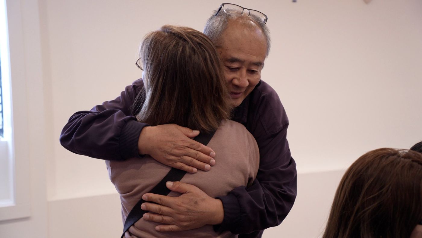 El voluntario Luke Leung da un abrazo sincero a una sobreviviente tras distribuir suministros. Foto/Renee Liu
