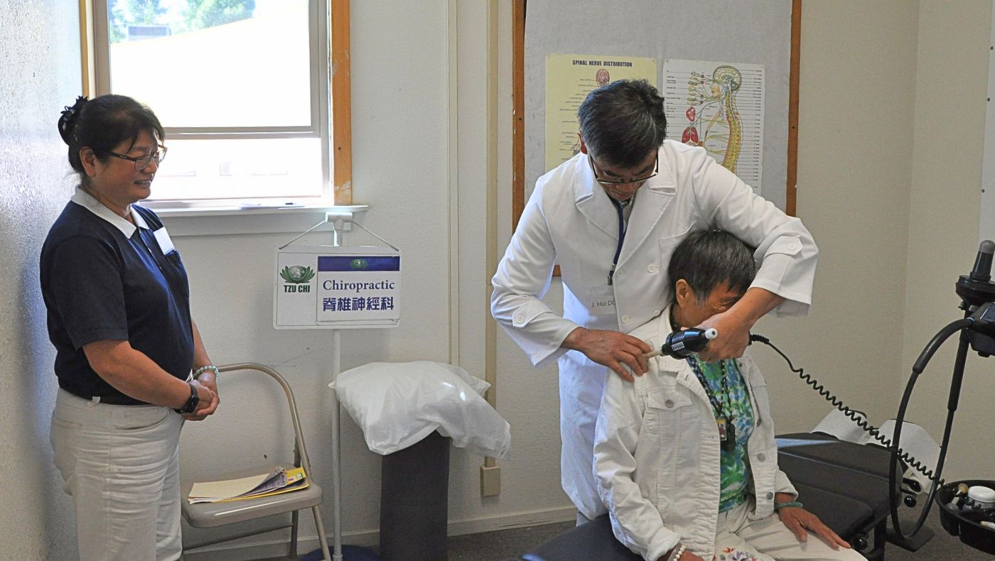 El quiropráctico Dr. John Hui y la asistente médica I’Ling Chen atienden a un paciente. Foto/Chih Kao Hsieh