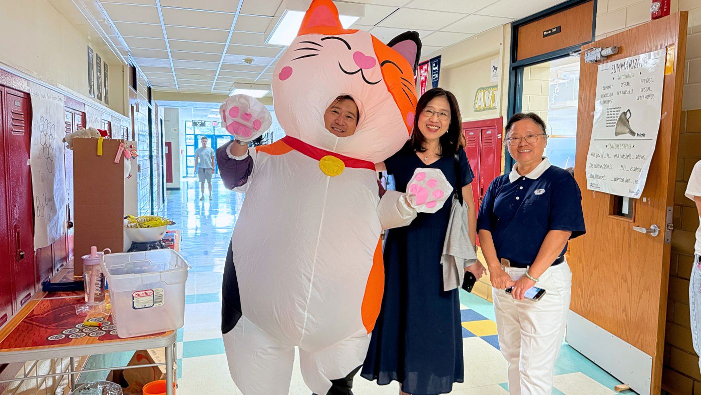 Wang Yingrong, Director of the Overseas Chinese Education Center, and Principal Cai Yijing posed for a group photo with the most popular giant cat at the event. (Photo by Wen Weiyao)