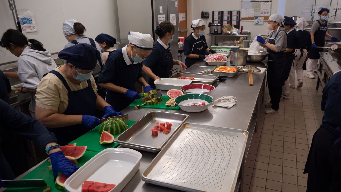 Los voluntarios preparan deliciosos platillos para que todos en la cocina trasera. Foto/Wen Chu