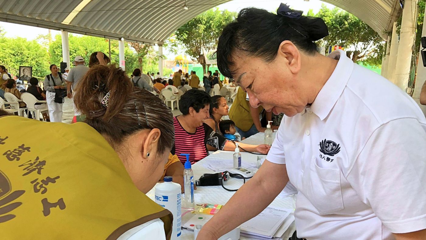2018 年 4 月 26 日,慈濟於墨西哥喬朱特拉 (Jojutla, Mexico) 舉辦義診活動, 志工吳志慧(右一)親切關懷民眾、協助醫療服務。攝影/林育貞