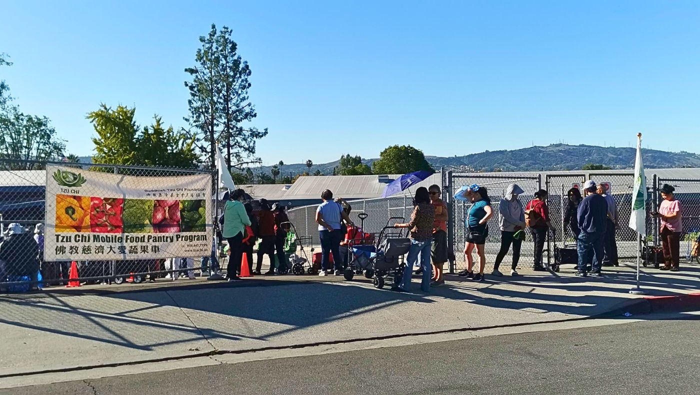 A large number of people lined up on the street outside the distribution site, waiting to enter. Photo by Chen Xiuwen