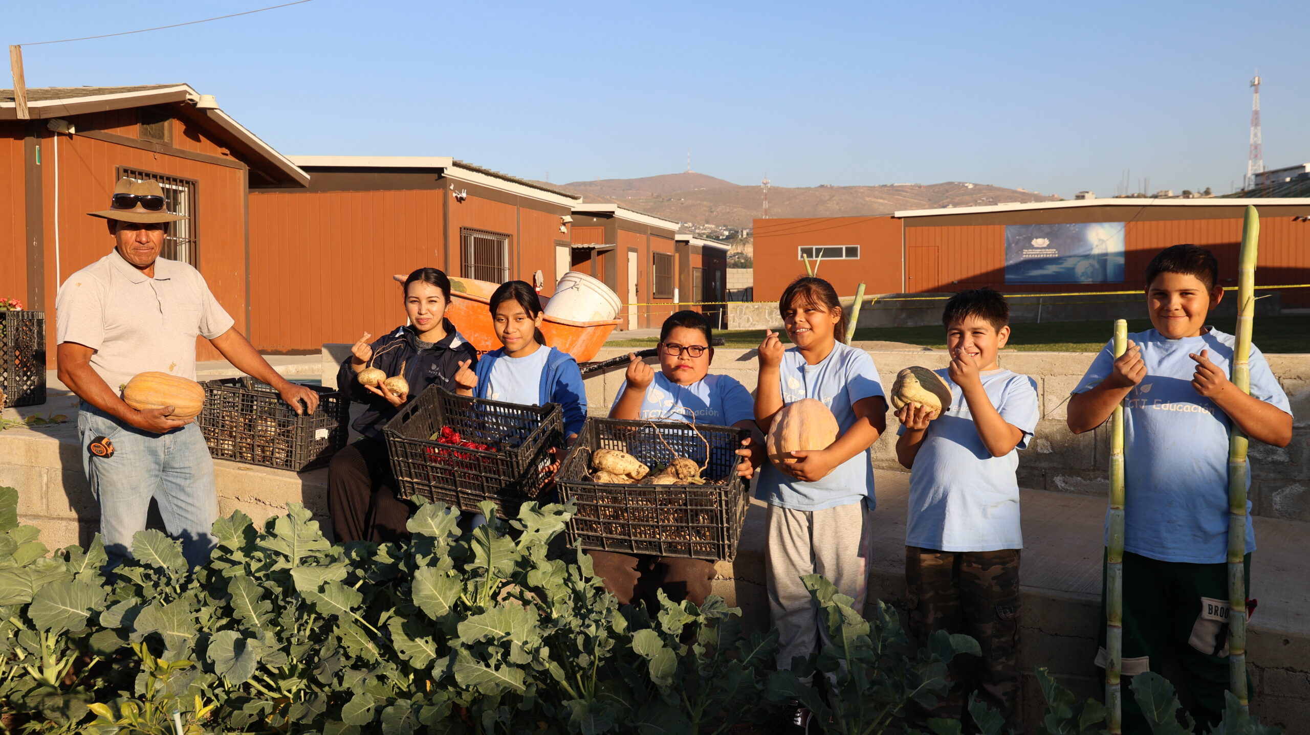Fabian, an employee of the Tzu Chi Foundation's Tiwana plantation in Mexico, works with children from the Hope Classroom to transform barren land into a fertile vegetable garden. (Photo by Luo Shuli)