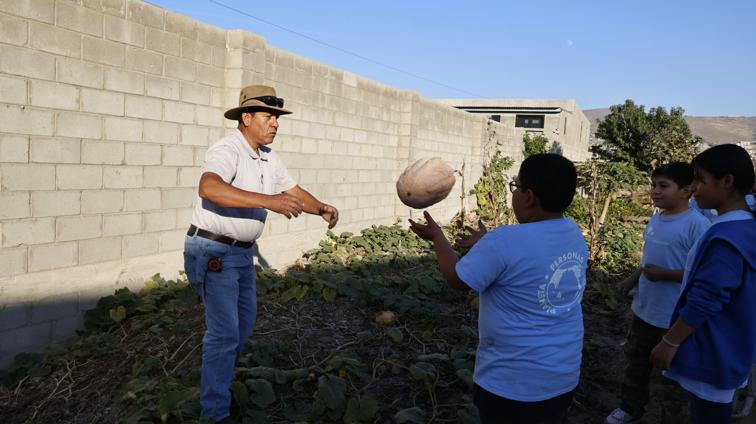 Fabian and the children of Hope Classroom have become green partners, working together perfectly while harvesting pumpkins. (Photography by Luo Shuli)