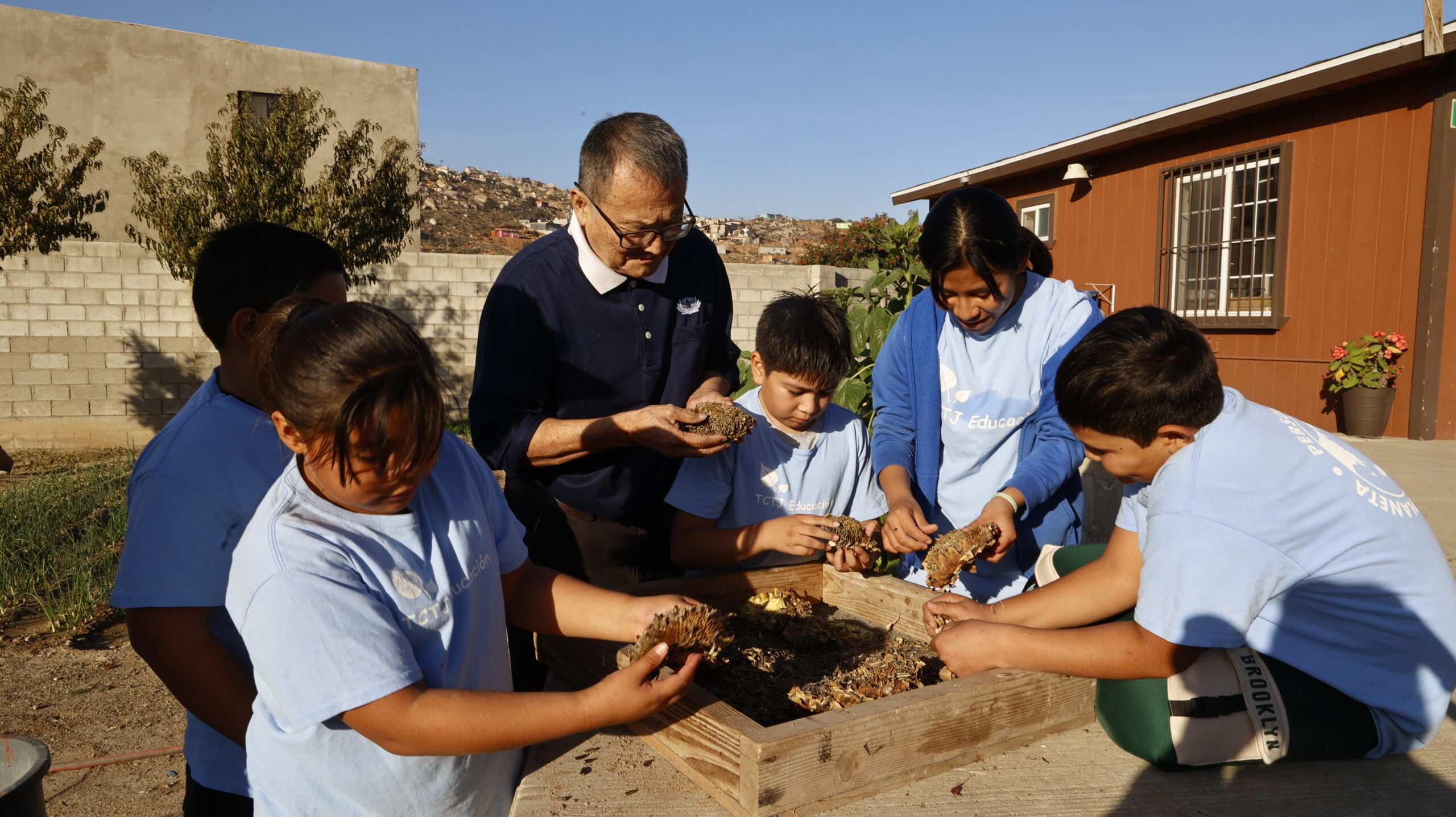 Volunteer Wang Sihong led the children in shelling sunflower seeds. Photo by Luo Shuli
