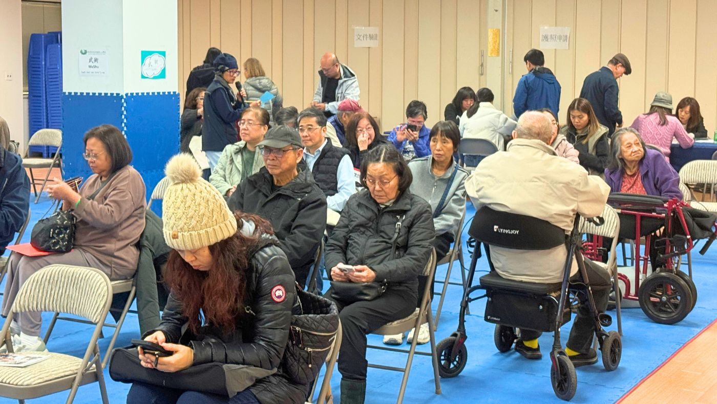 People in New Jersey who need to apply for licenses or permits sit in the waiting area waiting for their number to be called. Photo by Lin Shujuan