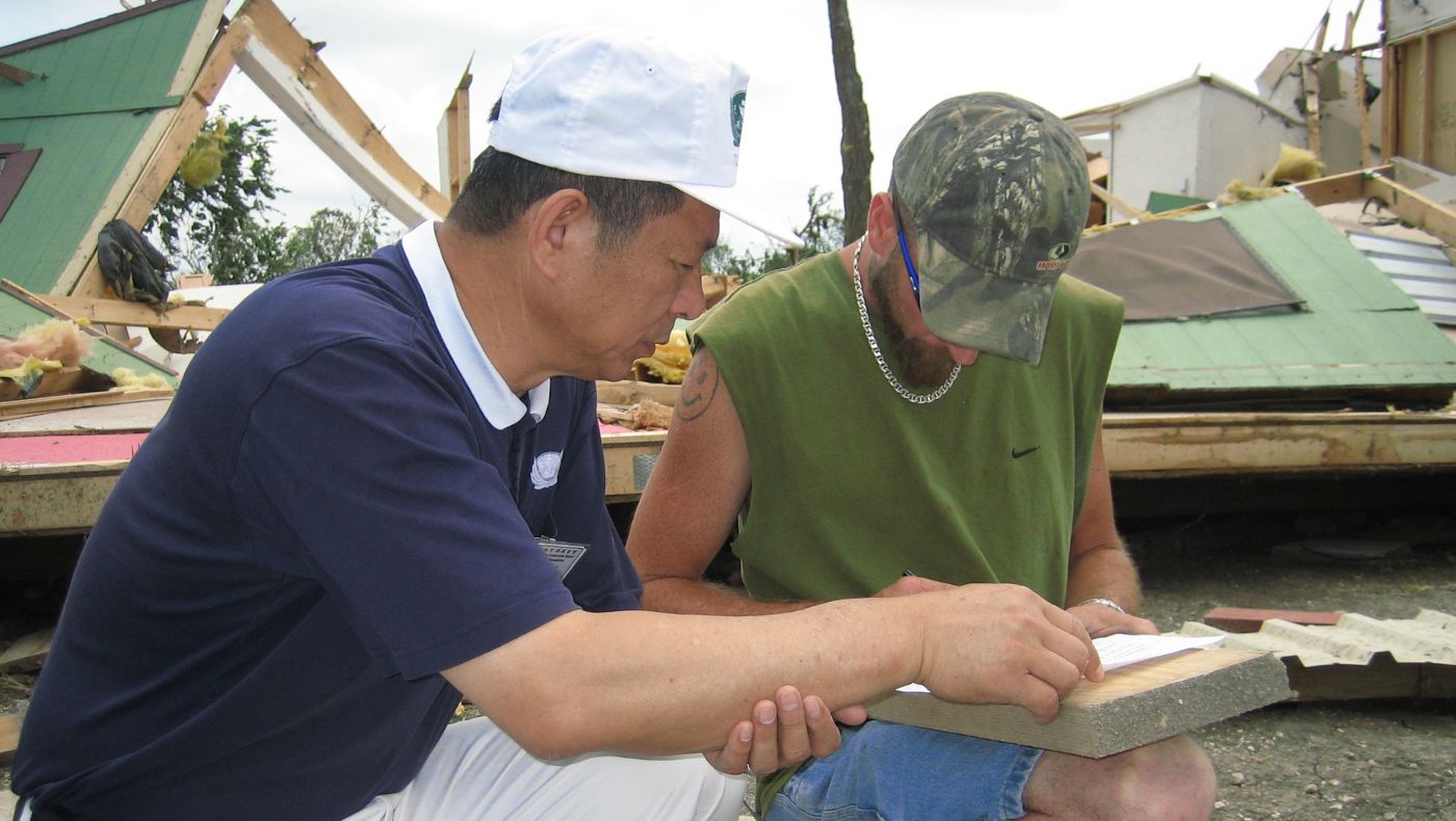 On May 10, 2006, during tornado relief efforts in Collin County, Texas, Tzu Chi volunteers in Dallas provided assistance to affected families and distributed cash value cards. Photo: Ling Yuanliang distributes cash value cards to disaster victims, conveying Tzu Chi's love and sincere blessings. Photo by Zeng Zhaowen.