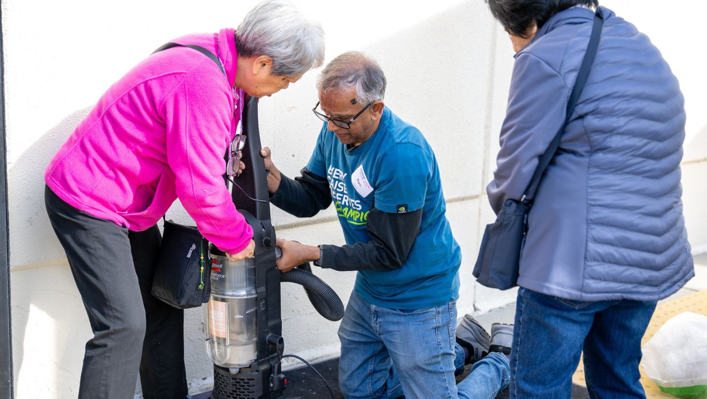 People watched with anticipation as volunteers helped repair malfunctioning vacuum cleaners. Photo by Chiang Kuo-an