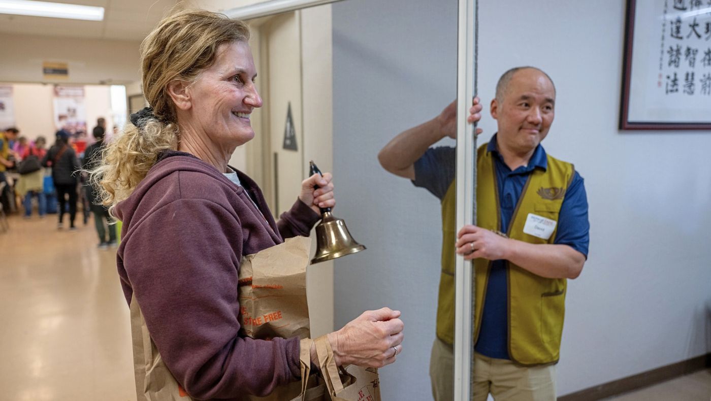 Jennifer (left) happily rang the bell after her aluminum screen door, which needed its rollers replaced, was repaired. Photo by Jiang Guoan