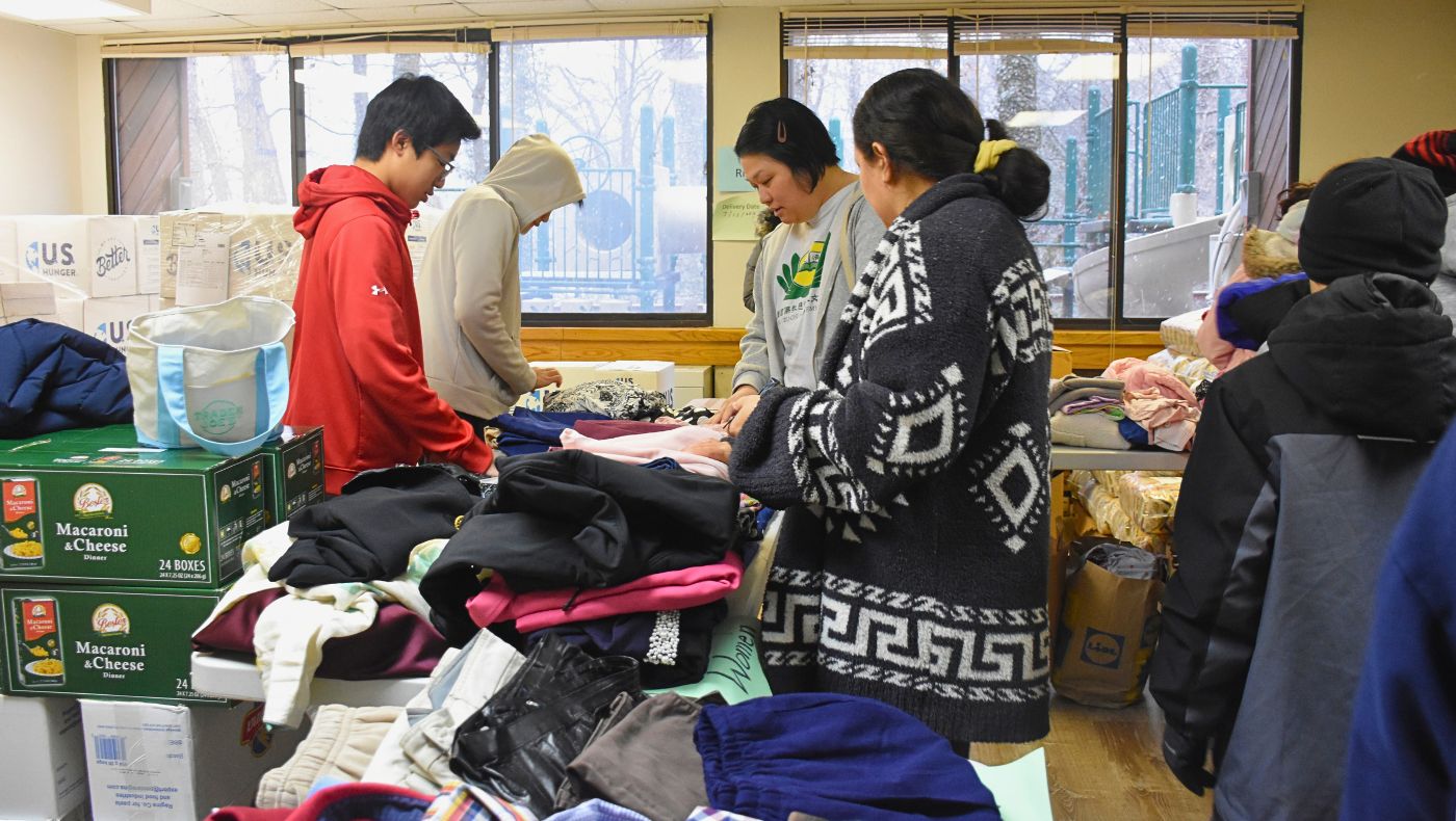 Teachers and students from the Tzu Chi Humanities School in Washington, D.C., help members of the public choose the winter clothing they need. Photo by Tsai Hui-ching