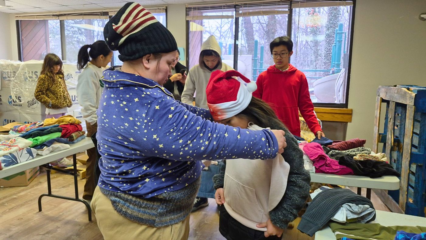 Families receiving assistance try on winter clothing donated by teachers and students of the Washington, D.C. Humanities School for their children. Photo by Tsai Hui-ching
