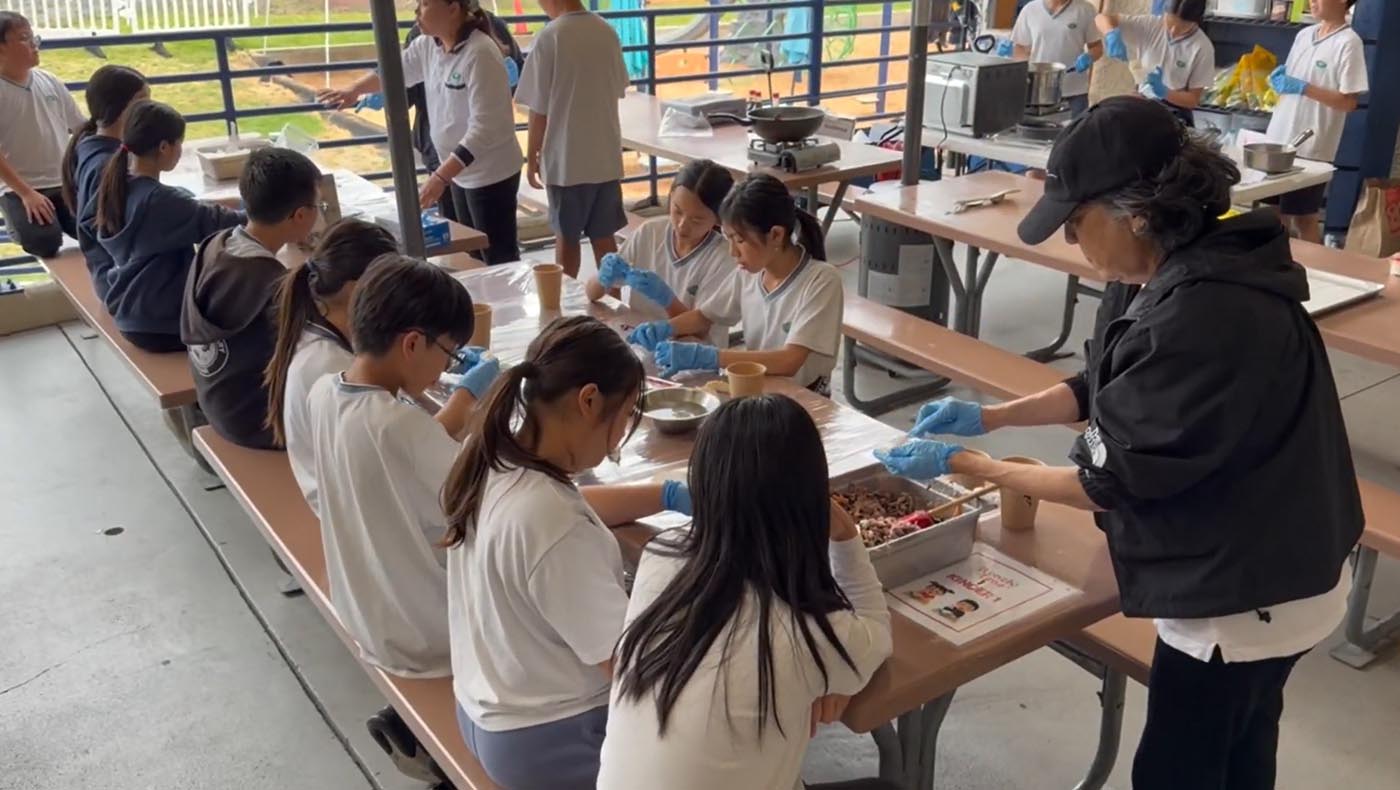 五、六年級學生穿上圍裙與手套，在「Fusion Kitchen」活動中分工合作，親手為家長準備充滿愛心的料理。圖片來源／視頻截圖