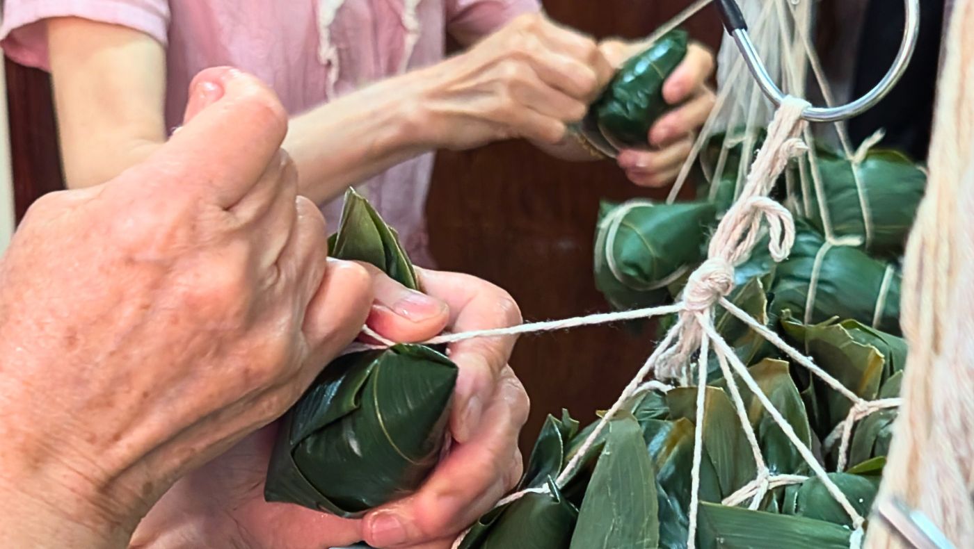 香積志工細心綑綁素粽。攝影／邱品豪