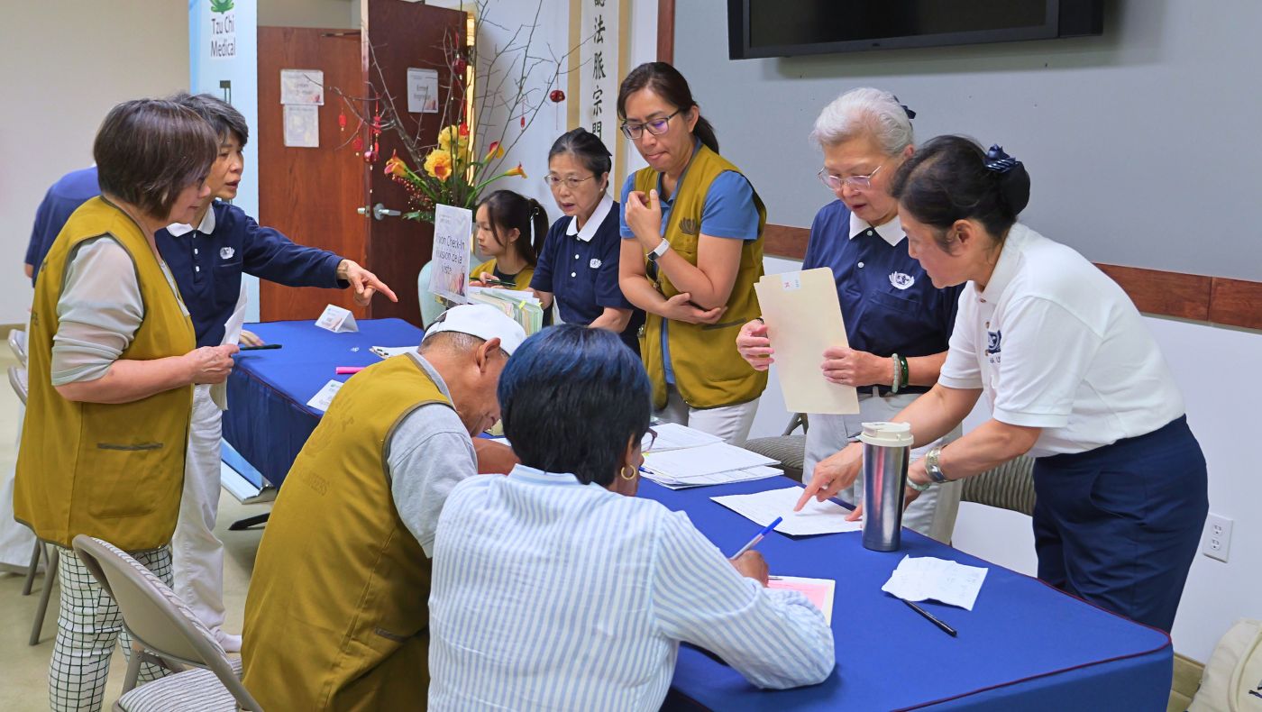 「法親健康關懷日」報到處有條不紊，志工笑迎每位法親。 攝影／高守勇