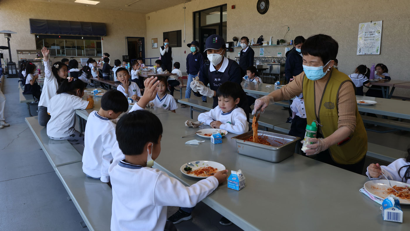 Children in the lower grades of elementary school are more independent, volunteers help the children who have good appetites refill their plates.