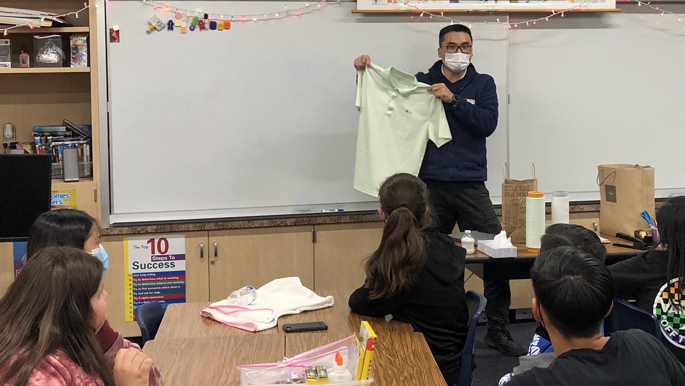 In the classroom, Xumu Huang shows the students clothes made from recycled plastic bottles. Photo/Ziwen Wang