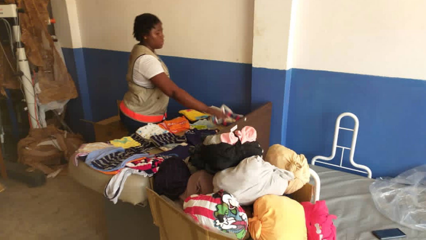 Sorting through box after box of donated clothes for the survivors. Photo/Courtesy of Caritas volunteers in the Republic of Sierra Leone