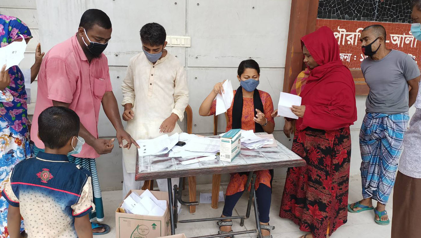 孟加拉慈濟本土志工5月28日在納拉揚甘傑縣（Narayanganj District）展開紓困發放，受疫情衝擊的民眾憑單據來領取物資。圖片來源／慈濟基金會