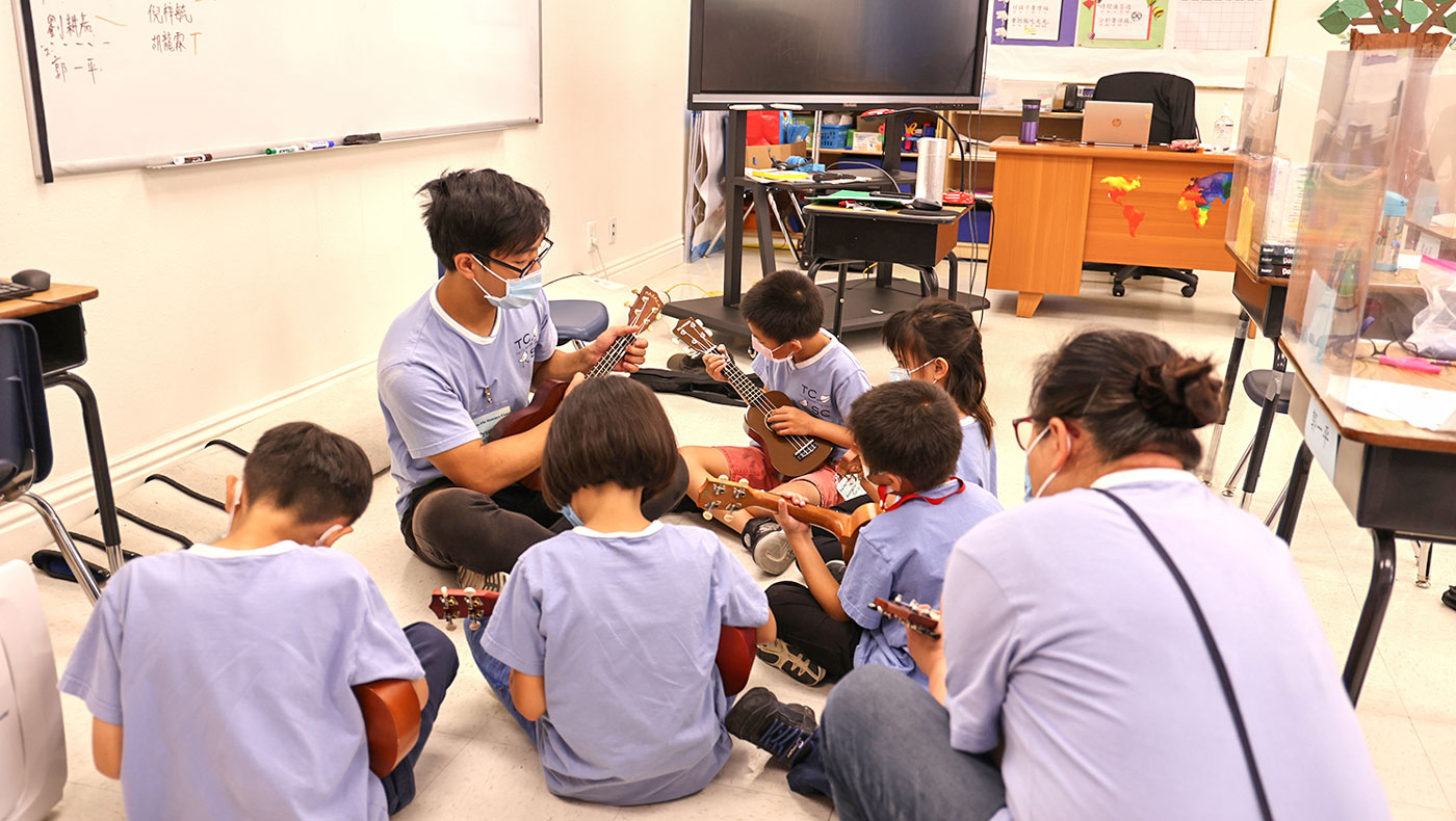 Students play the guitar together with their teacher. Photo/Shu Li Lo