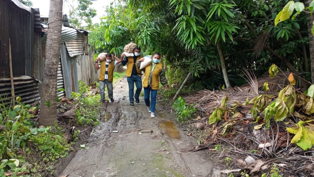 雨中道路泥濘，卡車到不了，步行用扛的。圖片來源／慈濟厄瓜多聯絡點