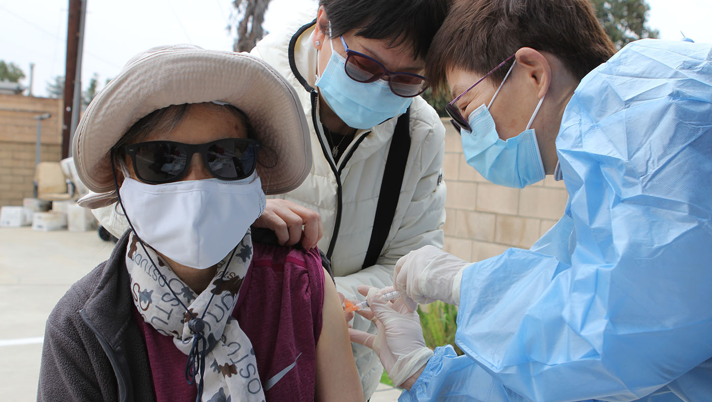 Una beneficiaria de Tzu Chi recibe una dosis de la vacuna COVID-19 en el centro médico de Tzu Chi en Los Angeles, California. Foto/Wesley Tsai