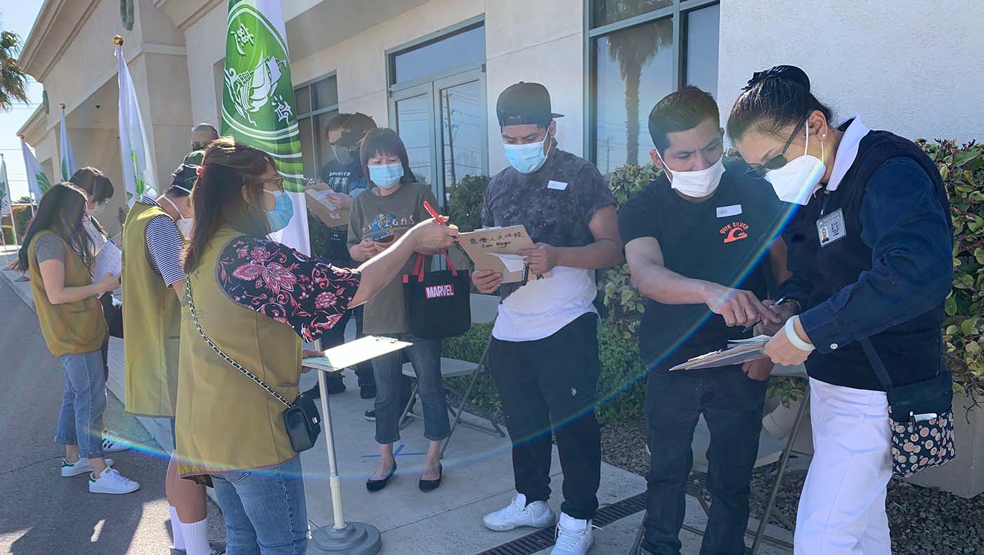 En Las Vegas, los voluntarios ayudan a las personas en fila a completar los formularios antes de recibir la vacuna. Foto/Audrey Cheng