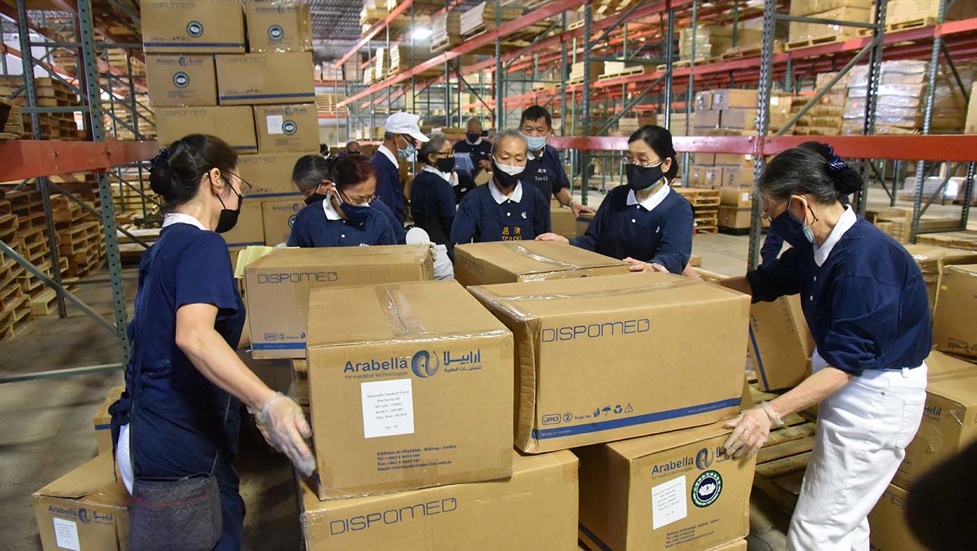 A pesar del calor y la alta temperatura en el depósito, los voluntarios empacaron los EPPs donados para enviarlos a Taiwán. Aunque estaban sudando, el trabajo no se detuvo. Foto/Shirley Wu