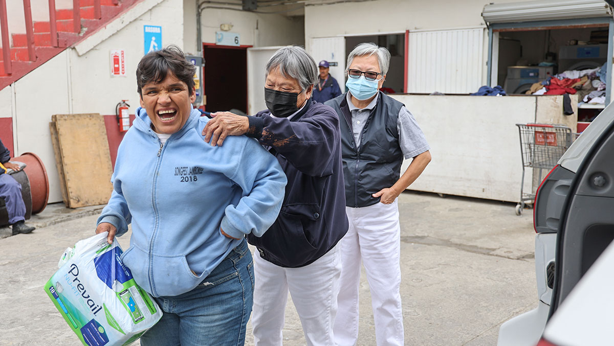 Ah Mui Manguy (segunda a la izquierda) que habla español ayuda a los beneficiarios que acuden al operativo. Foto/Shuli Lo