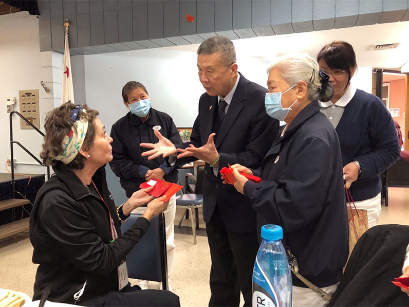 Tzu Chi volunteers giving Fuhui blessing envelope to the personnel of American Red Cross