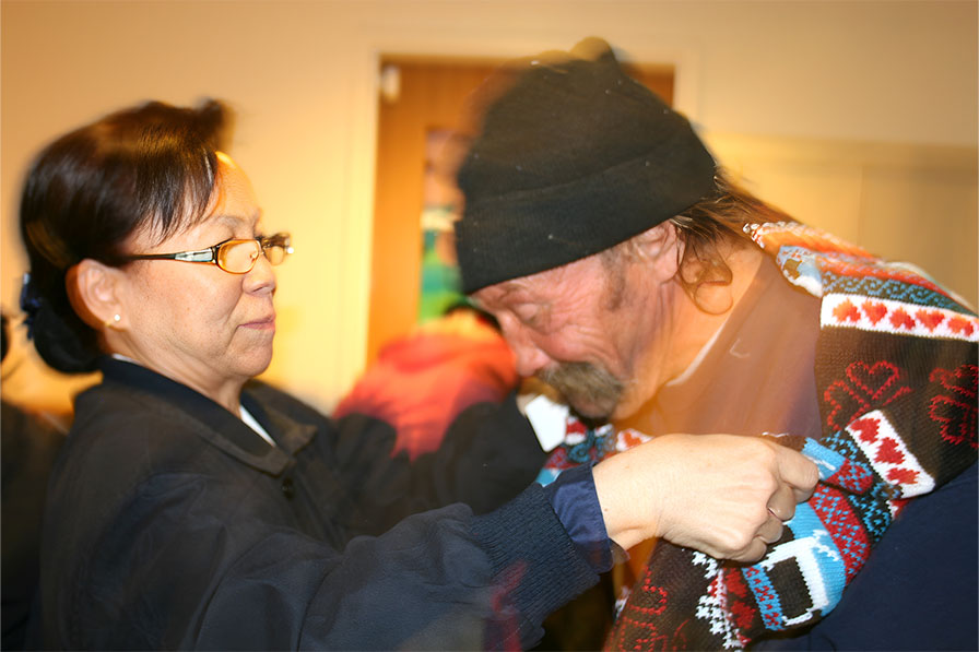 Tzu Chi volunteer putting scarf on the unhoused neighbor