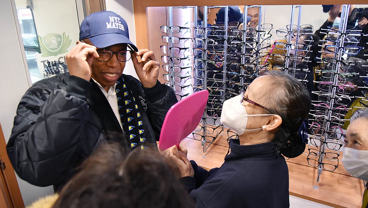 El Alcalde Adams se prueba unos lentes en la clínica. Foto/Hui Liu