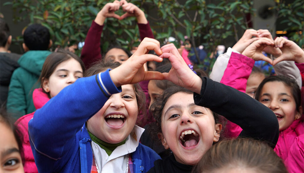 濟滿納海國際學校（El Menahil International School的特孩子們開心地對著鏡頭比著愛心和勝利的手勢