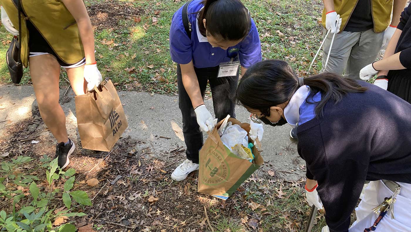 Tzu Chi Collegiate Association members from the University of Illinois aid one another during a community cleanup project. Photo/Courtesy of TCCA at UIUC