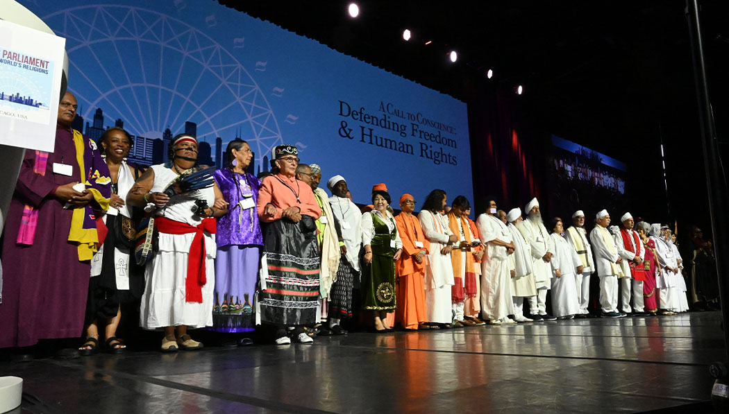 Representatives of diverse spiritual traditions gather on stage.
